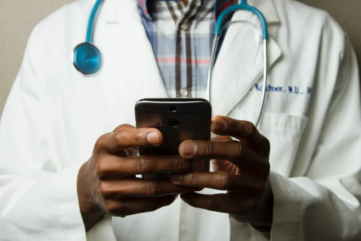 Doctor holding mobile device. Photographed by Daniel Sone for National Cancer Institute.